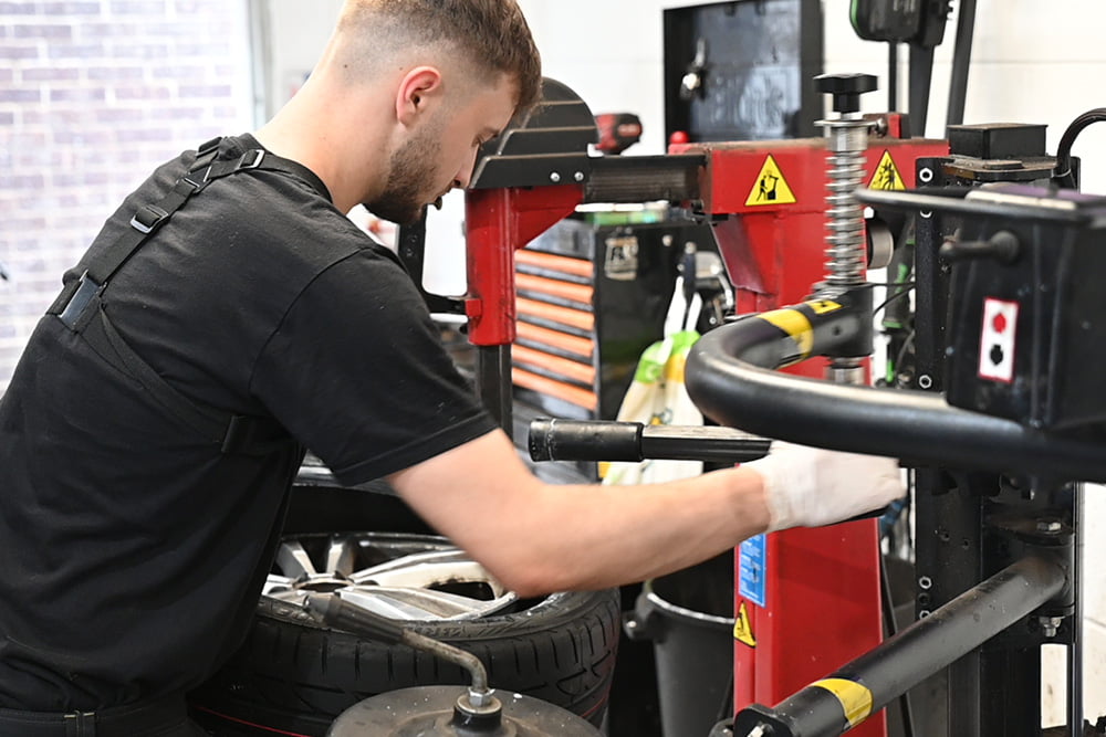 apprentice mechanic doing a tyre replacement