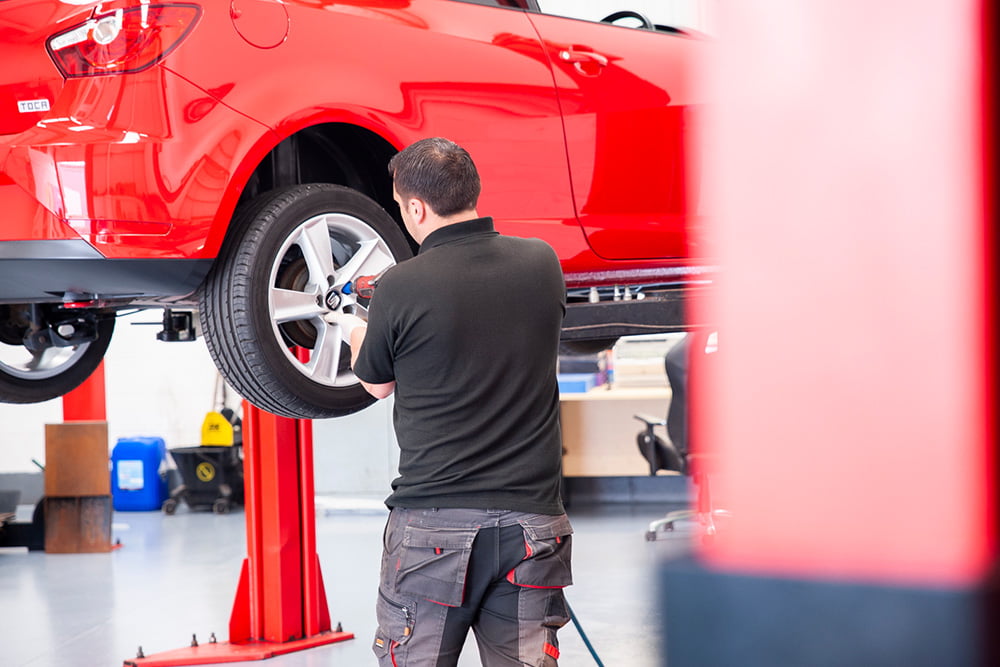 mechanic taking off wheel of seat ibiza red