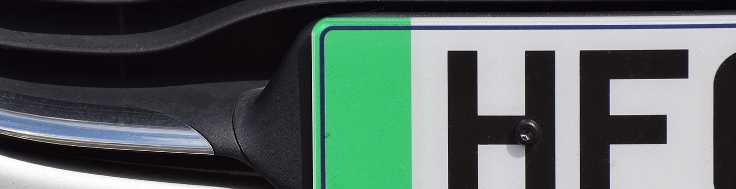 close up of white number plate with green section on it