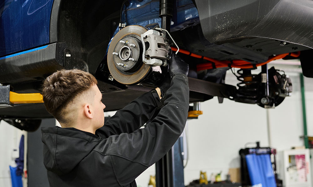 mechanic fixing suspension on a car