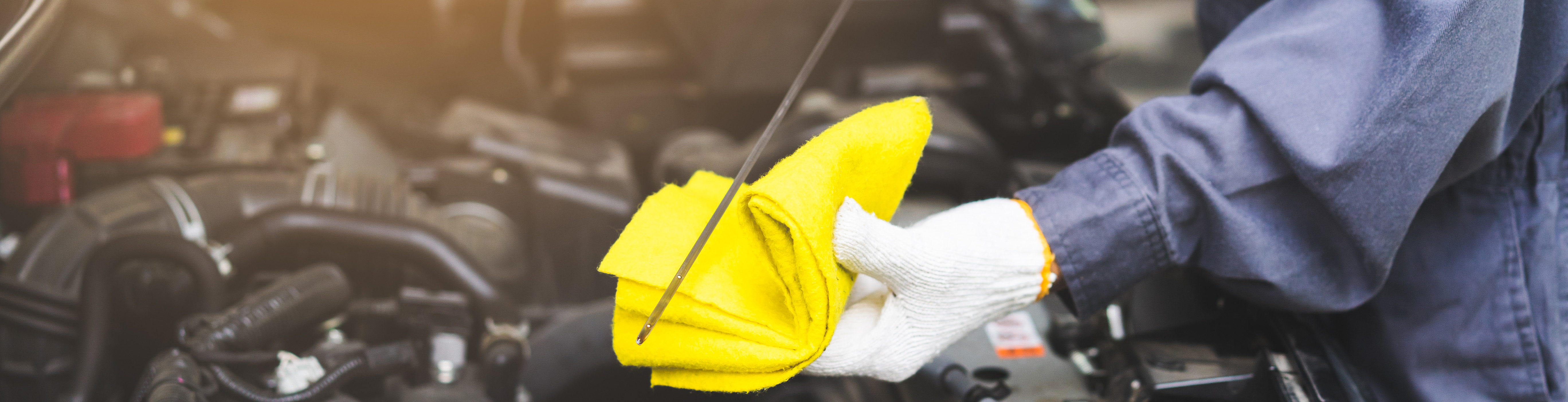 Wiping dipstick after checking oil.