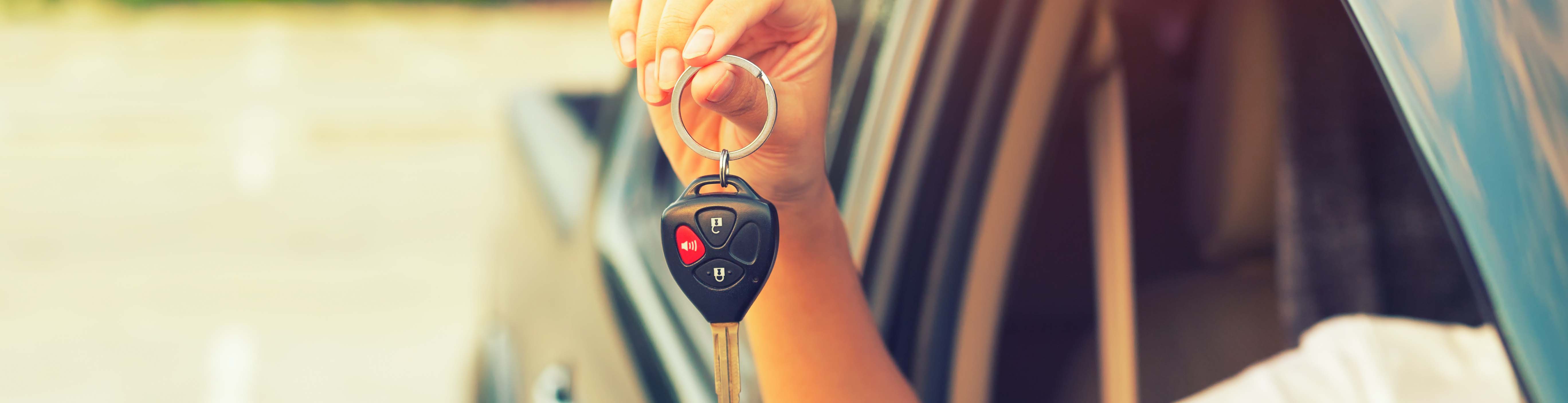 car key in hand holding out window